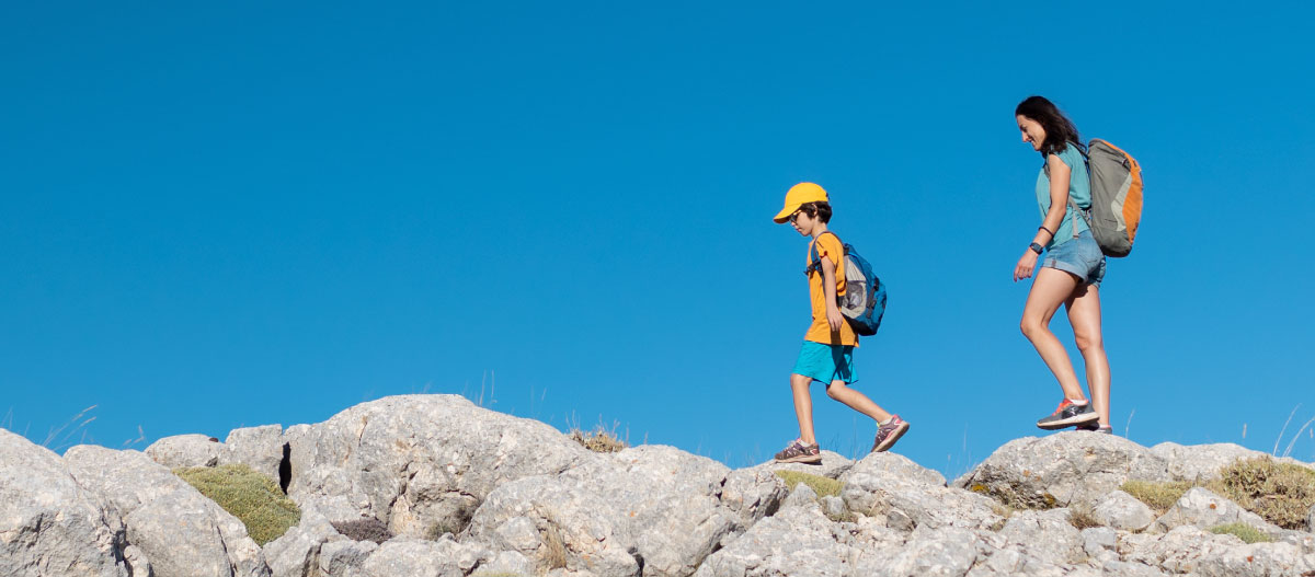 Mother and son walk on a hiking trail together