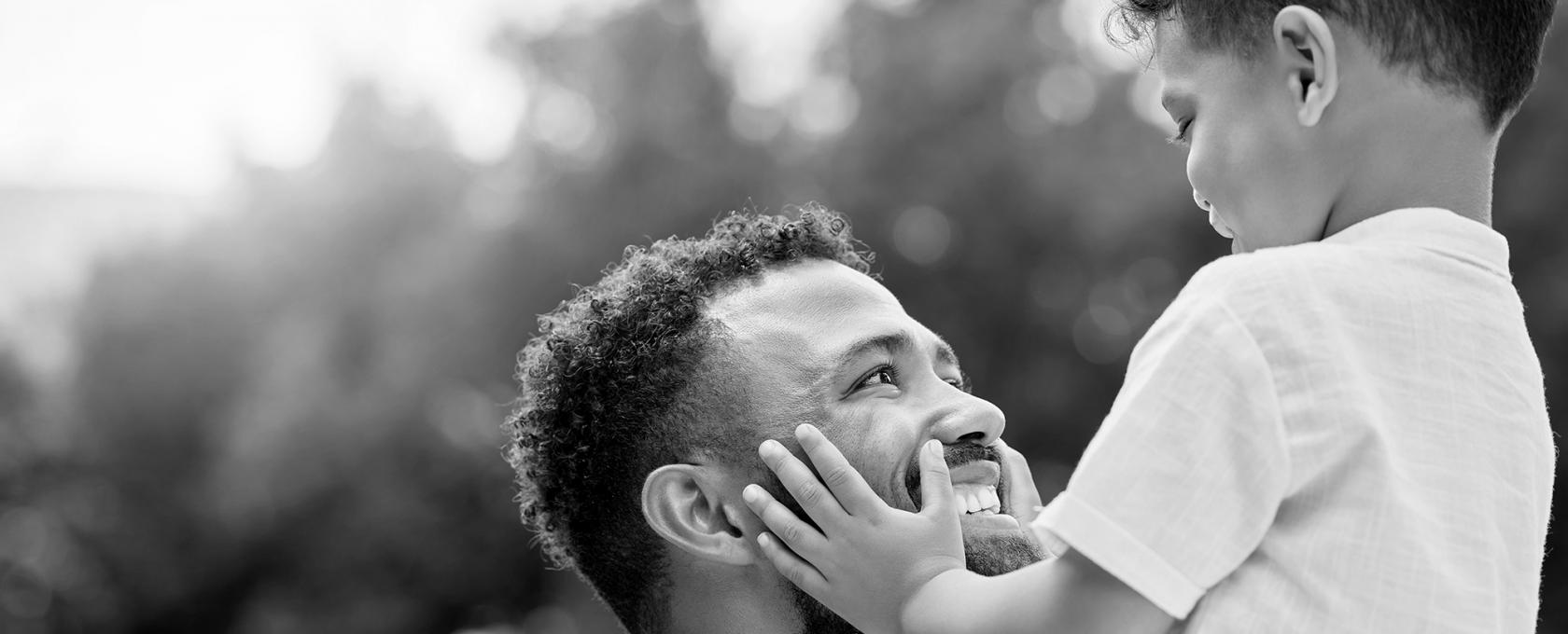 Father and young son looking at each other smiling