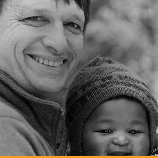 A father and infant son laugh together.